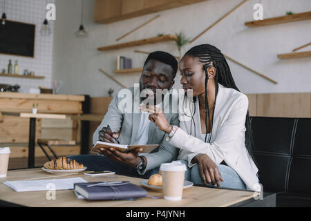 Afrikanische amerikanische Geschäftsleute diskutieren Arbeit während der Sitzung im Cafe Stockfoto