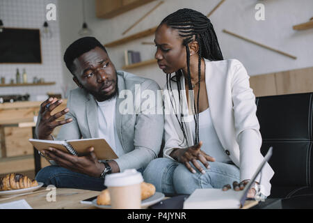 Afrikanische amerikanische Geschäftsleute diskutieren Arbeit während der Sitzung im Cafe Stockfoto