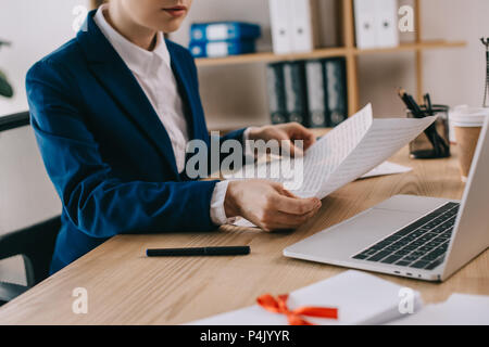 7/8 Schuß von geschäftsfrau Schreibarbeit tun am Arbeitsplatz mit Laptop im Büro Stockfoto