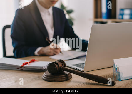 7/8 shot der weiblichen Rechtsanwalt Schreibarbeit tun am Arbeitsplatz mit Laptop und Hammer im Büro Stockfoto