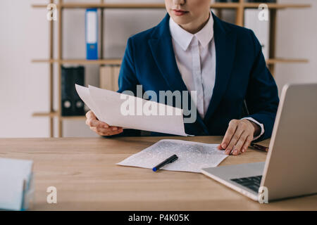 7/8 Schuß von Geschäftsfrau, die in der Klage Schreibarbeit tun am Arbeitsplatz im Büro Stockfoto