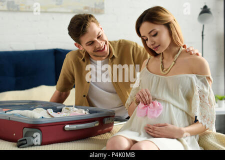 Die schwangere Frau und lächelnden Mann Vorbereitung Koffer für das Krankenhaus Stockfoto