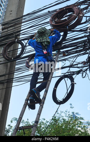 Arbeiter auf Leiter Arbeiten an Freileitungen und Kabel Stockfoto