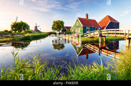 Traditionelle holländische Windmühle in der Nähe des Kanals. Niederlande, Landcape bei Sonnenuntergang Stockfoto