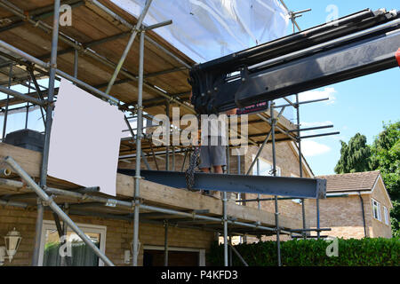 Ein Kran einen Balken in Position. Stockfoto