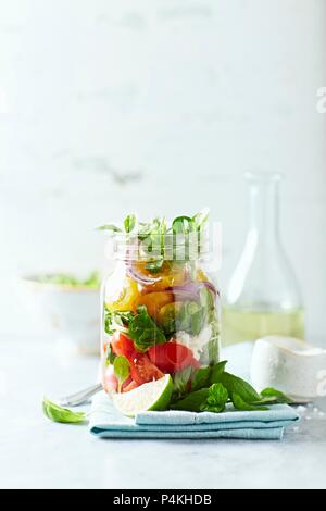 Cherry Tomaten Salat mit Mais und Salat Mozzarella in einem Glas Stockfoto