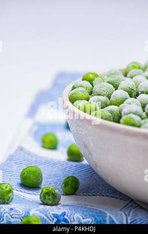 Frische Erbsen in eine Schüssel geben Stockfoto