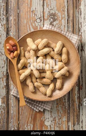 Erdnüsse auf einer Holzplatte Stockfoto