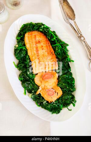 Hühnchen Roulade mit Schinken und Gewürzen auf sautierten Spinat Stockfoto