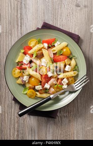 Mediterran Pasta Salat mit Tomaten, Zwiebeln und Feta Stockfoto