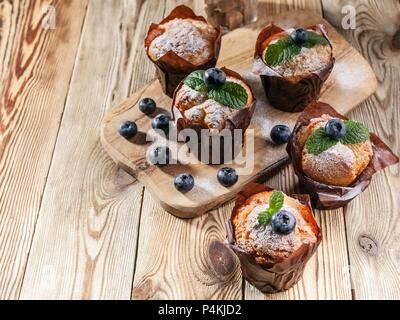 Muffins mit Heidelbeeren auf einer hölzernen Hintergrund. hausgemachte Backen Stockfoto