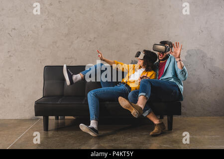 Erschrocken junges Paar mit Virtual reality Headset auf der Couch Stockfoto