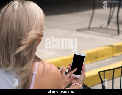 Blonde Frau mit einem Touchscreen Smartphone. Stockfoto