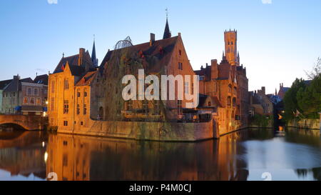 Blick auf historische Gebäude in der Nacht vom Rosenkranz Quay mit Reflexionen und der Glockenturm im Hintergrund, Brügge, Belgien Stockfoto