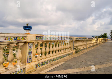 Geschnitzte Handlauf mit Keramik Muster und durch einen blauen Becken mit einem Kaktus in der Stadt Santo Stefano di Camastra im Norden Sizilien überwunden Stockfoto