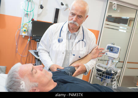 Männliche physio Therapeut behandelt ein älterer Mann Stockfoto