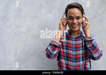 Junge schöne Inder gegen die Betonwand in den Straßen o Stockfoto