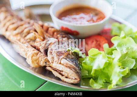 Frisch gebratenen Fisch mit Salat und pikanten Soße, Thai Food Konzept. Stockfoto