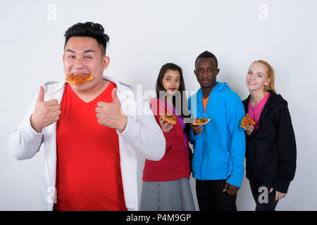 Studio shot der glücklichen jungen asiatischen Mann essen Pizza, während Stockfoto