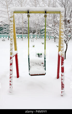 Kinder von Swing, bedeckt mit einer dicken Schicht Schnee nach einem starken Schneefall. Stockfoto