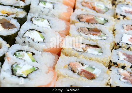 Nahaufnahme einer Menge sushi Rollen mit unterschiedlichen Füllungen. Makroaufnahme der gekochten klassisches japanisches Essen. Hintergrundbild. Stockfoto