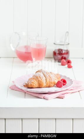 Breakfast with a croissant, raspberries, juice and raspberry jam Stockfoto