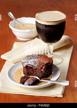 Schokoladenkuchen mit Vanillesauce und Irish Coffee Stockfoto