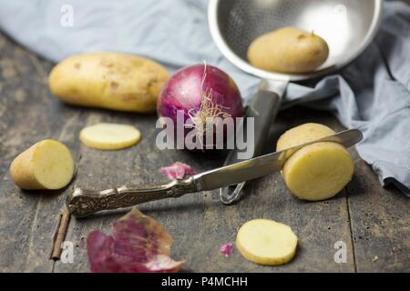 Rote Zwiebeln und Möhren auf einem rustikalen Tisch Stockfoto