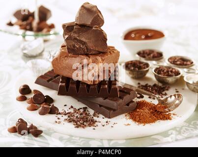Verschiedene Stücke von Schokolade, Schokolade, Chips, Kakaopulver und Kakaokerne Stockfoto
