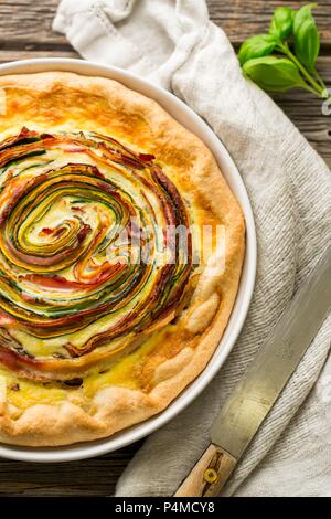 Eine Rose tart mit Zucchini, Karotten und Speck Stockfoto