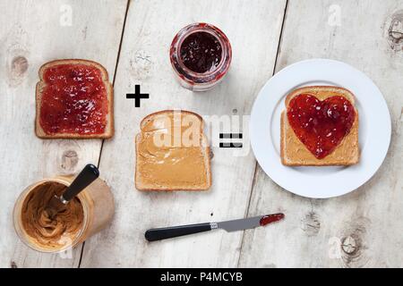 Gläser mit Erdnussbutter und Marmelade mit Erdnussbutter und Marmelade auf Brot; Herz Gelee auf Peanut Butter Brot Stockfoto