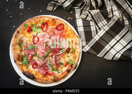 Pizza mit Schinken, Käse und Rucola Stockfoto