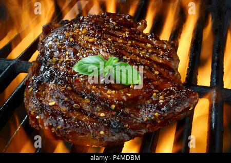 Rib Eye Steak auf einem brennenden Grill Stockfoto