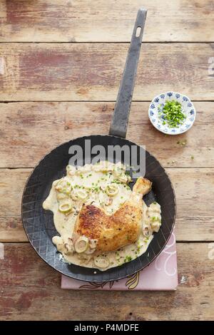 Ein hühnerbein in einer Schalotte und Sahnesauce Stockfoto