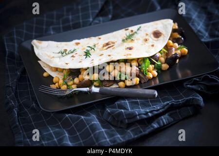 Eine vegane Weizen Fladenbrot gefüllt mit Kichererbsen, Pilze und Rucola Stockfoto