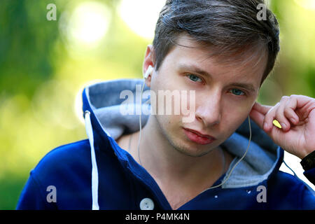 Belarus, Gomel, 15. September 2016. Central Park, einen Urlaub in der Stadt. Porträt eines jungen Mannes mit Kopfhörern Stockfoto