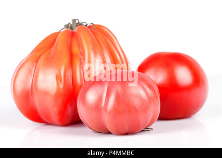 Drei Tomaten verschiedener Arten und Größen auf weißem Hintergrund. Stockfoto