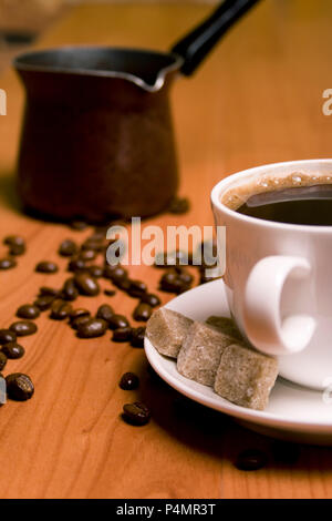 Tasse Kaffee, Caffee, Zucker und Bohnen auf hölzernen Tisch Stockfoto