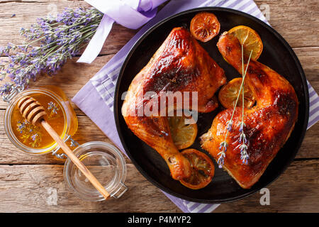 Französisch Essen: Gebratene viertel Hähnchenschenkel mit Lavendel Honig, Gewürzen und Zitrone close-up auf einem Teller auf den Tisch. Horizontal oben Ansicht von oben Stockfoto