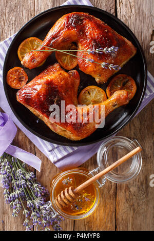 Französisch Essen: Gebratene viertel Hähnchenschenkel mit Lavendel Honig, Gewürzen und Zitrone close-up auf einem Teller auf den Tisch. Vertikal oben Ansicht von oben Stockfoto