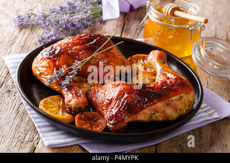 Französisch Essen: Gebratene viertel Hähnchenschenkel mit Lavendel Honig, Gewürzen und Zitrone close-up auf einem Teller auf den Tisch. Horizontale Stockfoto