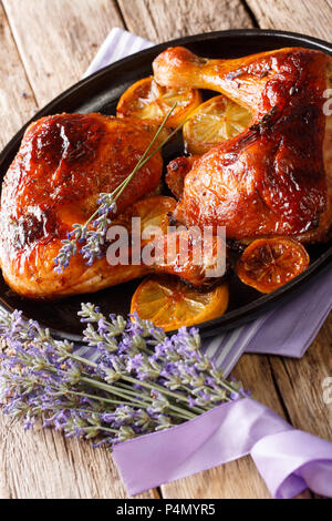Französisch essen: gebackene Hähnchenschenkel mit Lavendel Honig und Zitrone close-up auf einem Teller auf den Tisch. Vertikale Stockfoto