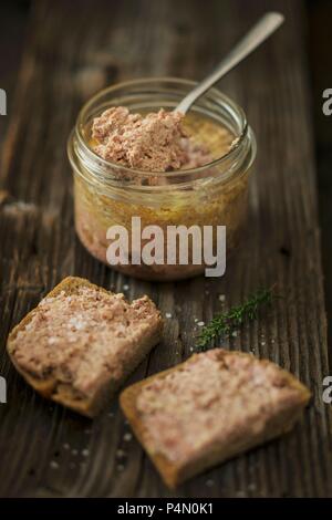 Gans Leberpastete in einem Glas und auf Scheiben Brot Stockfoto