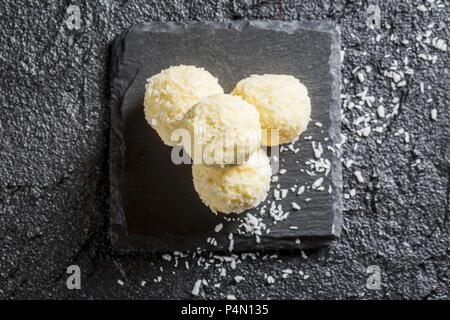 White coconut Pralinen auf einen schwarzen Stein Stockfoto