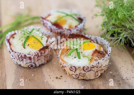 Gebackene Eier mit Speck in Papier Fällen Stockfoto