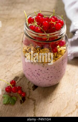 Ein Frühstück Glas mit Joghurt, cheia Samen und rote Johannisbeeren Stockfoto