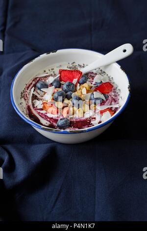 Coconut Joghurt mit Blaubeeren, getrocknete Erdbeeren, geröstete Nüsse und Kokos Chips Stockfoto