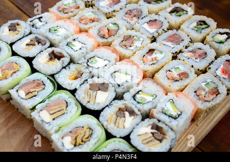 Nahaufnahme einer Menge sushi Rollen mit unterschiedlichen Füllungen. Makroaufnahme der gekochten klassisches japanisches Essen. Hintergrundbild. Stockfoto