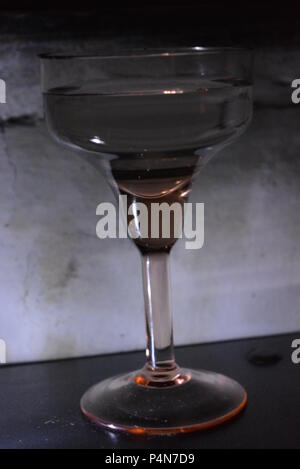 Schönes, stilvolles Foto von Partys, Feiern, ein schönes Glasglas auf weißem Hintergrund mit weißer Hintergrundbeleuchtung. Stockfoto