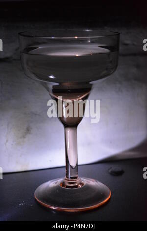 Schönes, stilvolles Foto von Partys, Feiern, ein schönes Glasglas auf weißem Hintergrund mit weißer Hintergrundbeleuchtung. Stockfoto